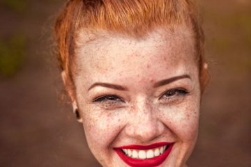 woman taking photo while showing smile